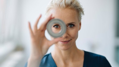 Frau schaut durch rundes Objekt