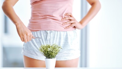 Frau steht vor Pflanze