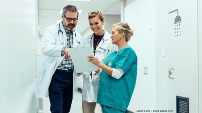 Ärztin und Arzt unterhalten sich mit Krankenpflegerin