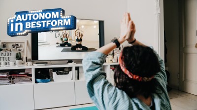 Frau macht Yoga vor Fernseher