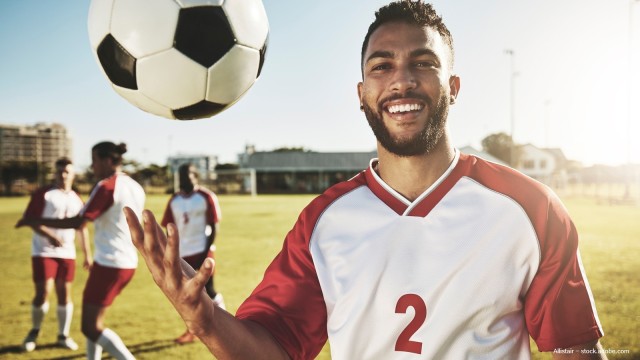 Fußballspieler mit Fußball auf dem Feld