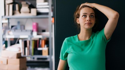 Frau steht vor Kühlschrank und schaut frustriert