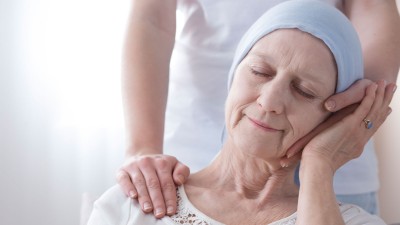 Frau mit Kopftuch wird tröstend gestützt