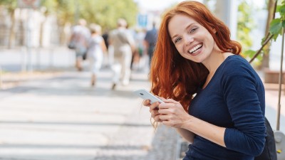 Frau mit Handy lacht