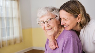 Frau umarmt ältere Frau von hinten