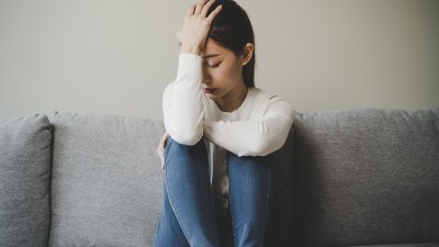 Frau stützt Kopf mit Hand ab