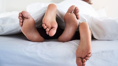 Füße schauen unter Decke hervor