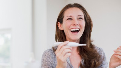 glückliche Frau mit Schwangerschaftstest