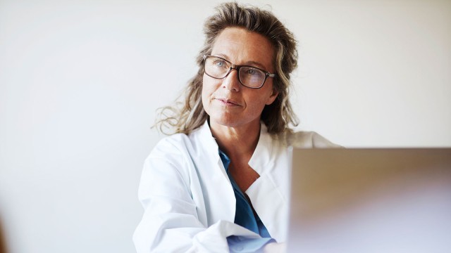 Ärztin sitzt vor Laptop.