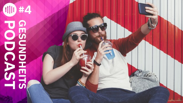 Eine Frau und ein Mann trinken aus Bechern und machen ein Selfie