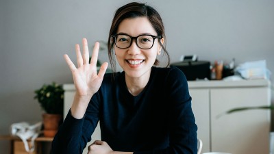 Frau winkt in Kamera