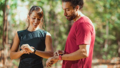 Sportler schauen auf ihre Smartwatch
