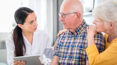 Frau gibt Ehepartnern Informationen über ein Tablet