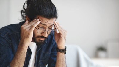 Junger Mann mit Kopfschmerzen