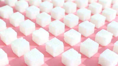 Raffinierter Zucker auf pinkem Hintergrund