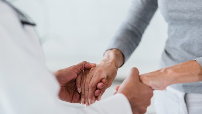 Arzt hält die Hände einer Patientin