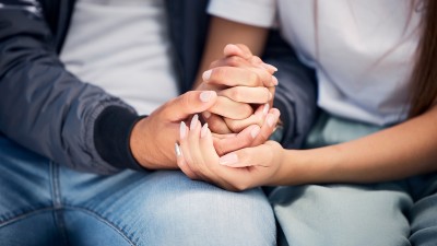 Ein Mann und eine Frau halten Hände.