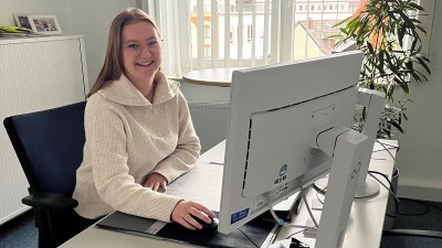 Auszubildende Pia Meyer sitzt in ihrem Büro am Schreibtisch.