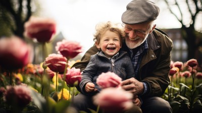 Großvater und Enkelsohn spielen gemeinsam im Garten.