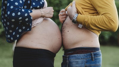 Schwangere Frau und Mann mit nackten Bäuchen