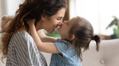 Ein Kind küsst seine Mutter auf die Nasenspitze