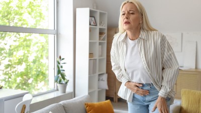 Eine Frau leidet unter Unterleibschmerzen.