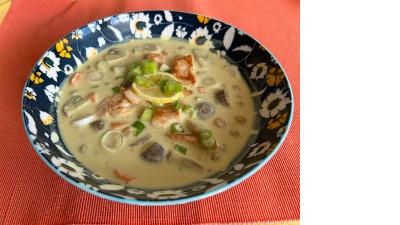 Blick auf einen Suppenteller mit Kokos-Gemüsesuppe mit Hähnchen.