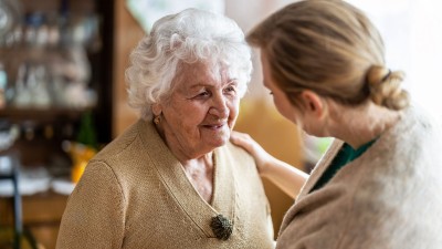 Junge Frau im Gespräch mit alter Frau