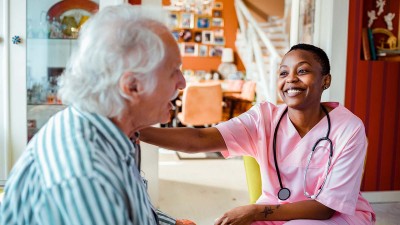 Pflegekraft legt Hand auf Patienten