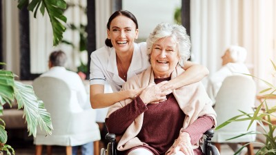 Pflegekraft umarmt ältere Frau