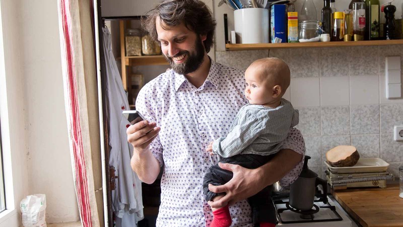 Mann mit Baby und Handy