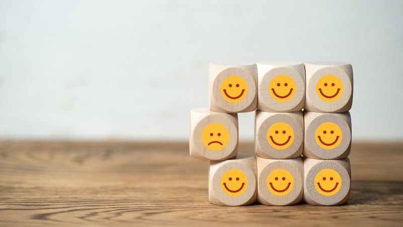 Ein unzufriedener Smiley unter lächelnder Smileys