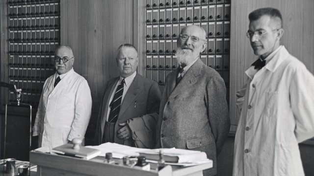 Vier Männer in einer Apotheke. Der zweite von rechts ist Robert Bosch. 